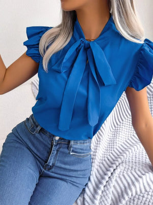 Royal blue pussy-bow blouse with ruffle sleeves and a tie neck, worn with jeans.