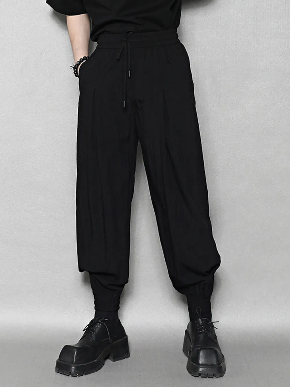 Black sweatpants with drawstring waist and ankle cuffs.