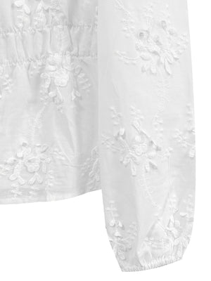 White embroidered blouse with balloon sleeves and cinched waist detail.