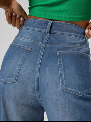 Medium wash wide-leg denim jeans with contrast cuff detail shown from the back.