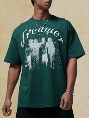 Dark green oversized graphic tee with white "Dreamer" text and distressed figures.