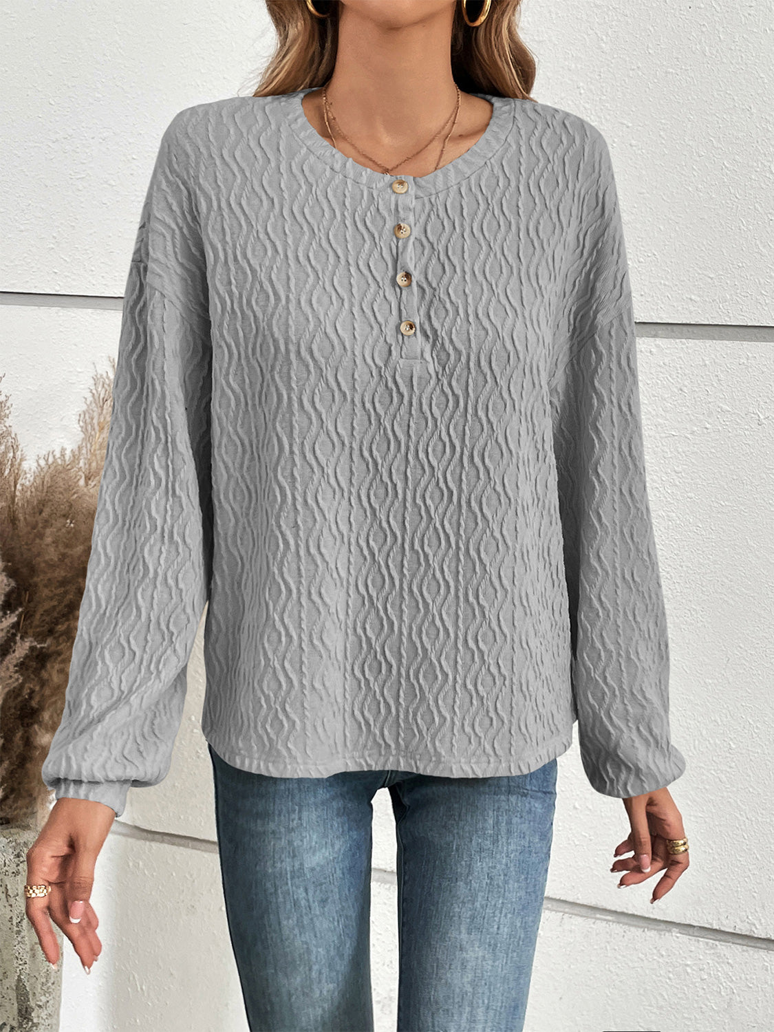 Textured grey henley blouse with button detail and blouson sleeves.