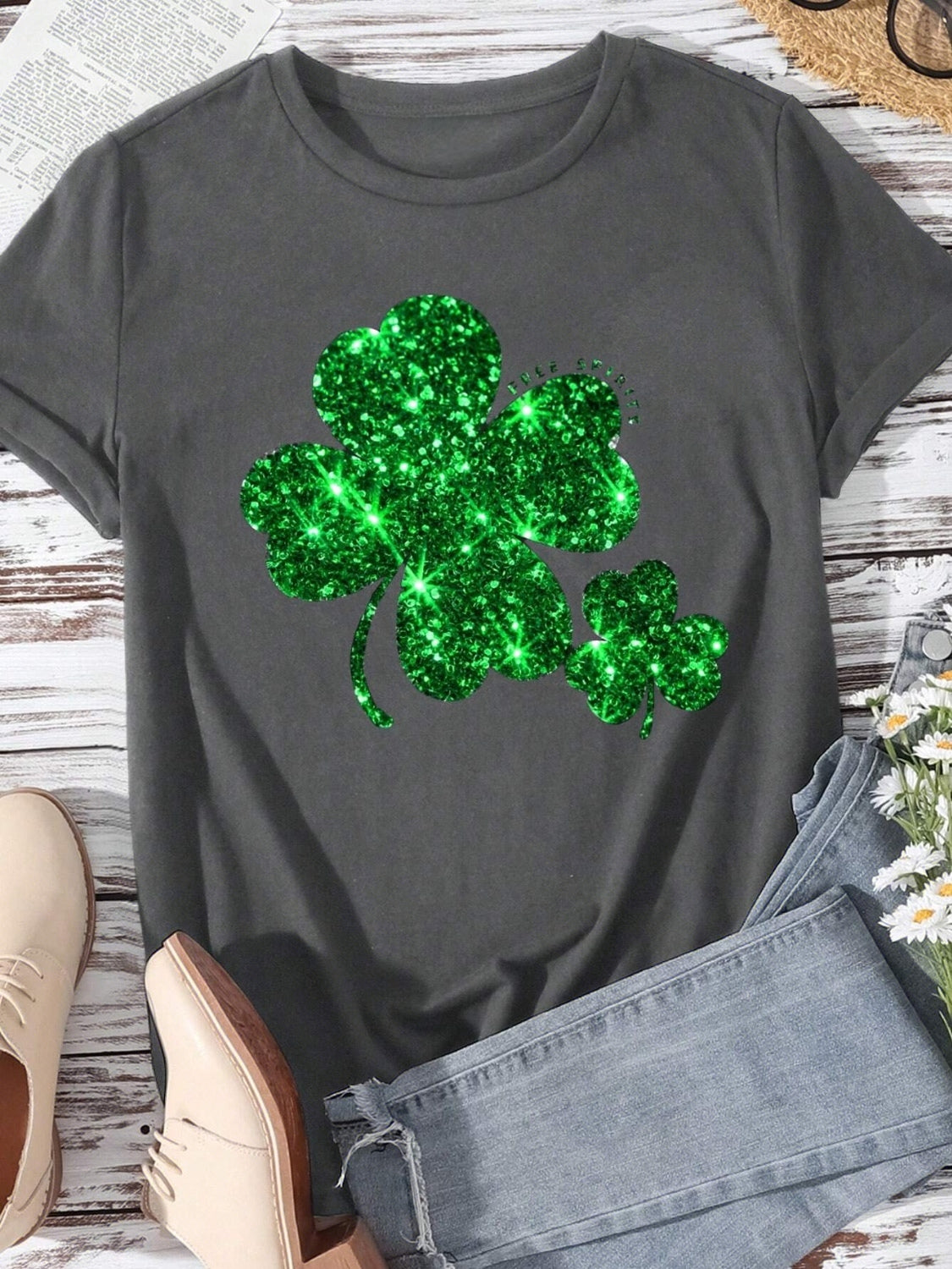 Dark gray t-shirt with a large, sparkling emerald green glitter shamrock graphic.