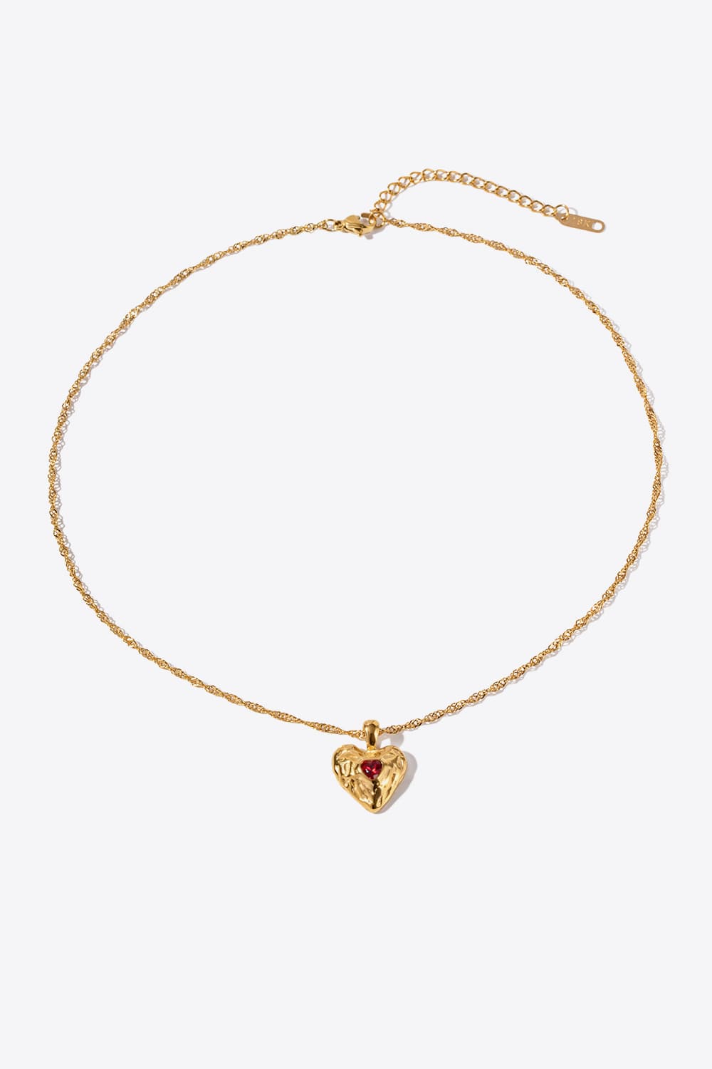 Textured gold heart pendant necklace with red stone on a delicate chain