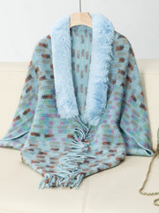 Pastel blue knit poncho with plaid pattern, faux fur collar, and fringe detail.