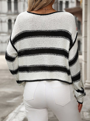 Horizontal stripe knit cropped sweater in black and white acrylic, with a crew neck and long sleeves.