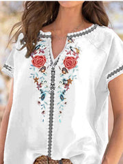 White blouse with floral embroidery and notched neckline.