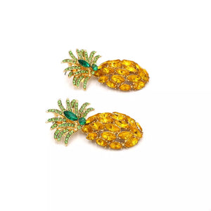 Pineapple-inspired dangle earrings with gold metal, yellow oval rhinestones, and green leaf accents.