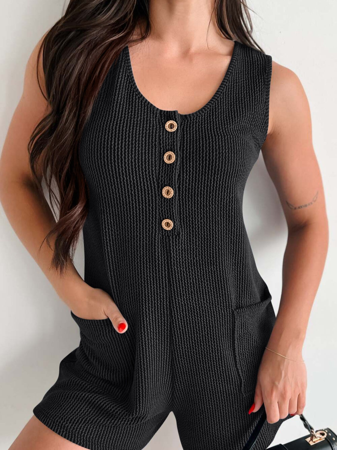 Black textured button-down pocket romper with gold buttons and scoop neck.