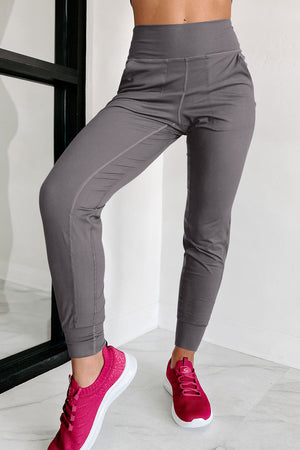 Dark gray joggers with performance fit and comfort, featuring subtle stitching details and elastic cuffs.