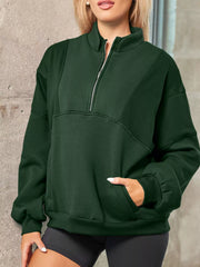 Dark green half zip stand collar sweatshirt with a front pocket and ribbed cuffs.