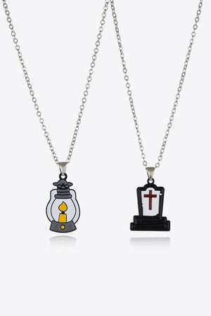 Spooky Season enamel pendant necklaces, one with a lantern, one with a tombstone and cross.