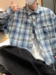 Blue plaid long-sleeve buttoned shirt with chest pocket, worn open over white tee.