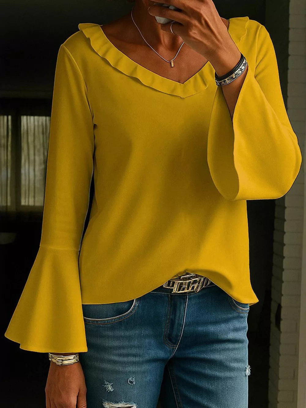 Ochre polyester blouse with V-neck ruffle and bell sleeves.