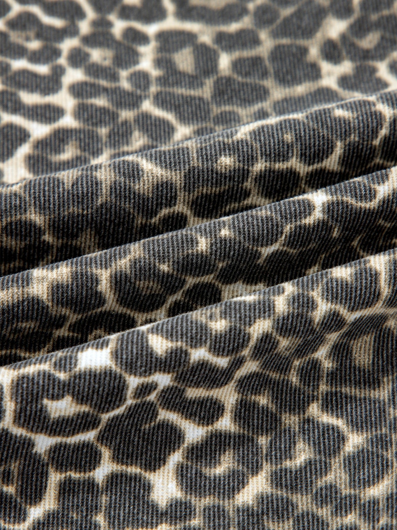 Denim shirt with leopard print, featuring a textured weave and classic animal pattern.