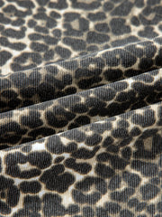 Denim shirt with leopard print, featuring a textured weave and classic animal pattern.