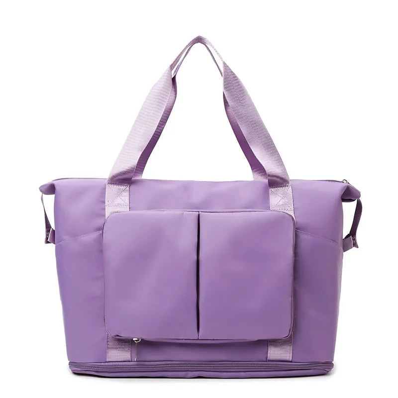 Foldable travel tote in Plum Purple with exterior pockets and zippered bottom compartment.