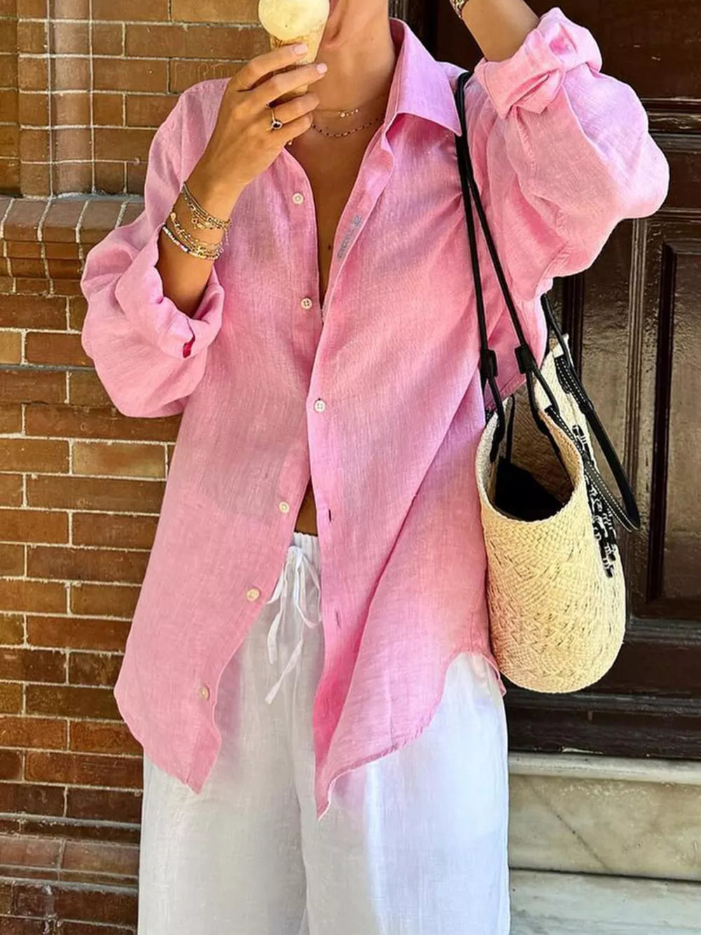 Relaxed oversized pink cotton button-up shirt with long sleeves and a collared neckline.