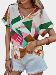 Geometric print V-neck blouse in multicolor with short sleeves.
