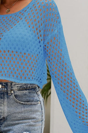 Blue cropped open knit top with bell sleeves and a scoop neckline, styled with denim shorts.