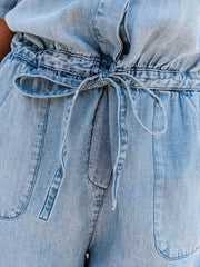 Light wash denim romper with shirred waist and tie detail