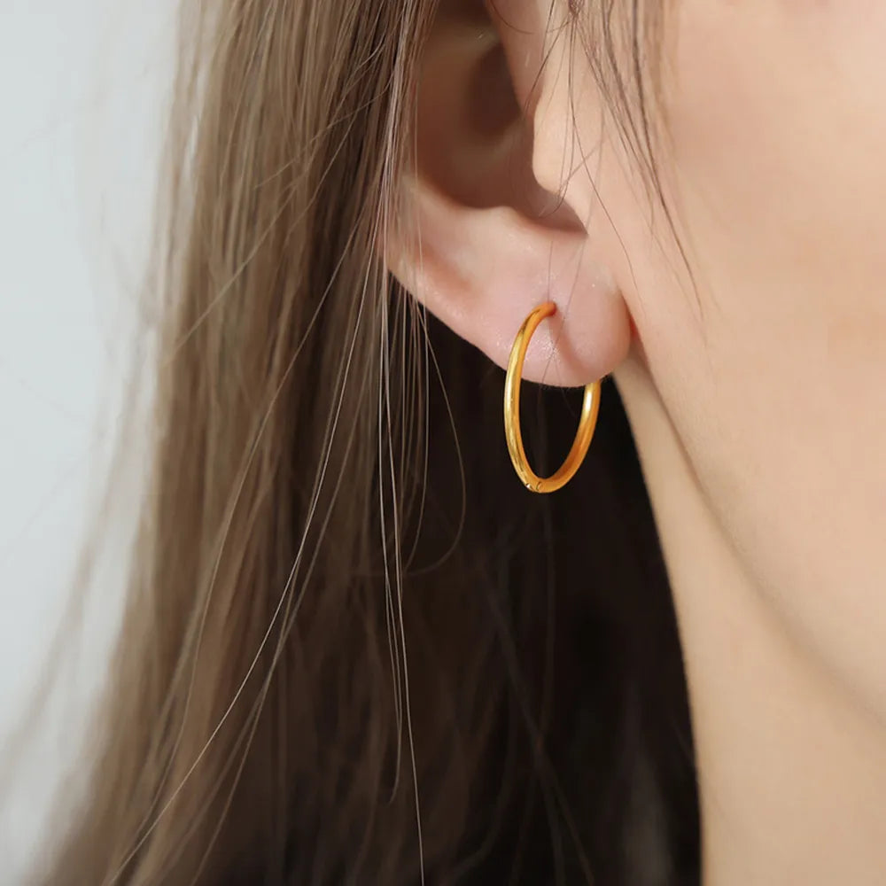 Minimalist gold vermeil huggie earrings in Style A, close-up on ear.