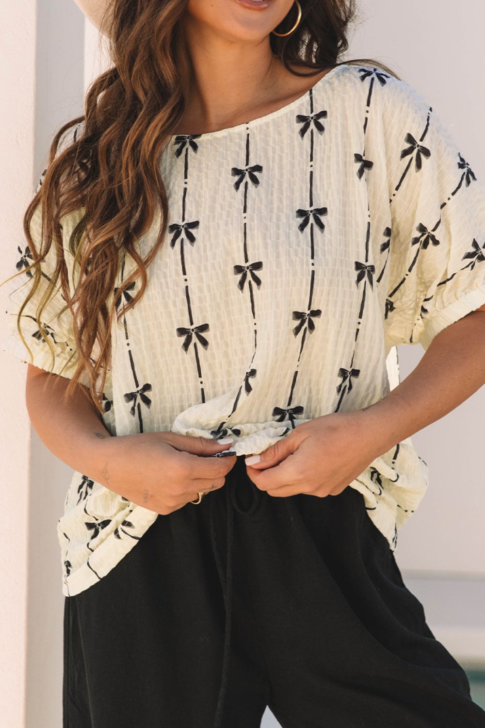 Beige gauze blouse with black bow print and gathered sleeves.