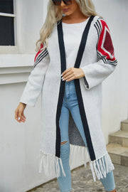 Long grey cardigan with black trim, geometric red and black sleeves, and fringed hemline.
