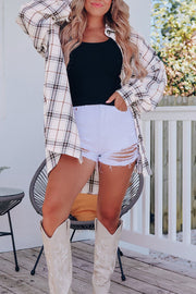 Oversized white plaid shacket with button front and chest pockets, worn open over a black tank top.