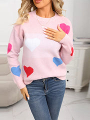 Pink acrylic knit sweater with multicolor heart pattern, round neck, long sleeves.