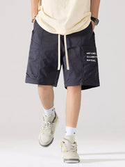 Navy blue cotton cargo shorts with adjustable drawstring and side pocket text detail.