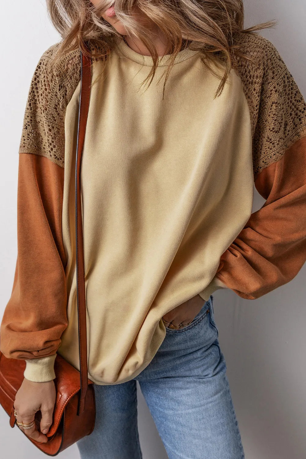 Tan sweatshirt with crochet yoke and raglan sleeves, featuring a colorblock design.