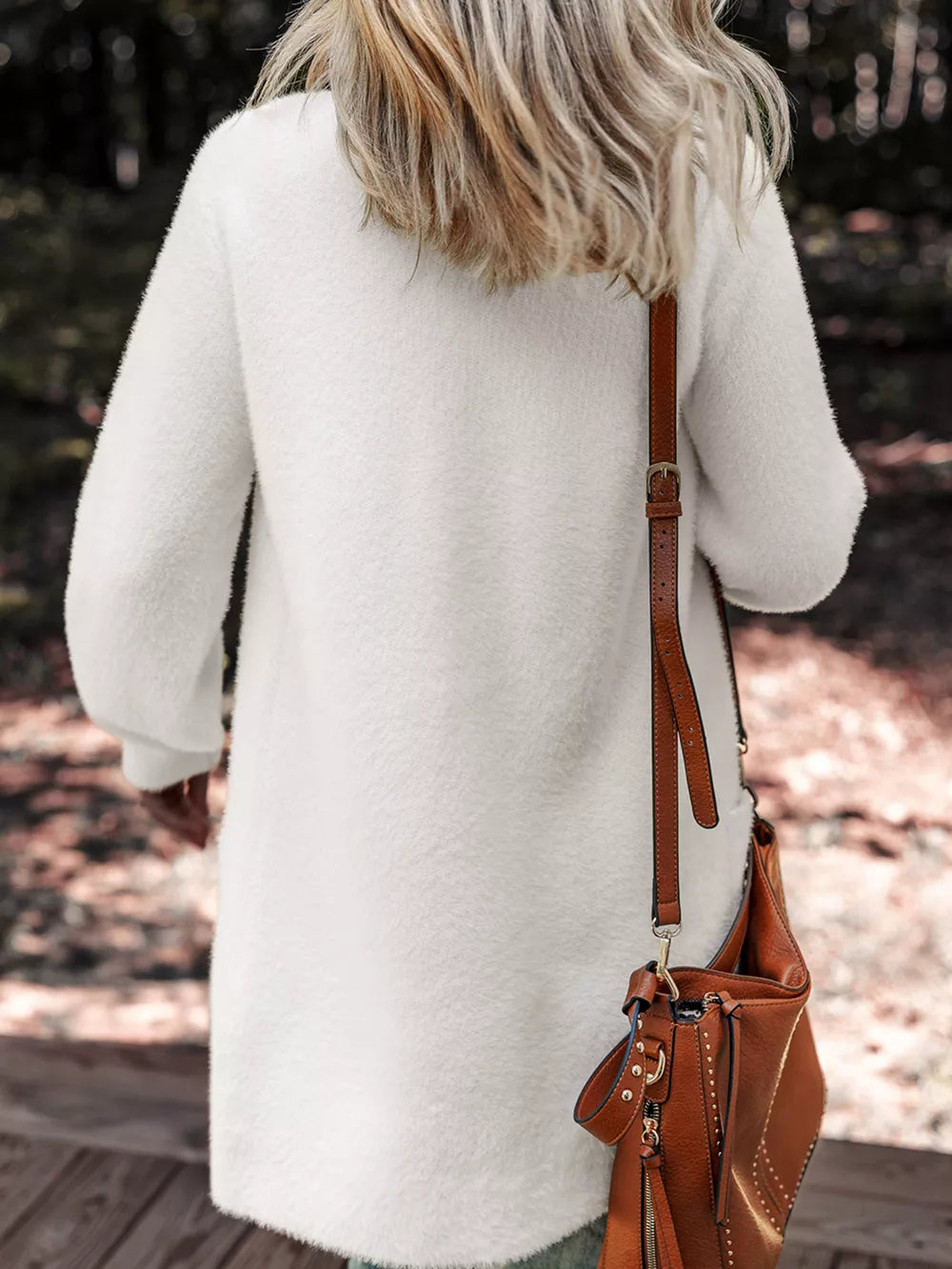 White fuzzy long sleeve cardigan with pockets, shown from the back.