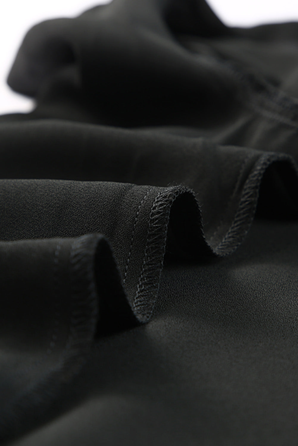 Black tie-front blouse with ruffled sleeves and a button-down front.