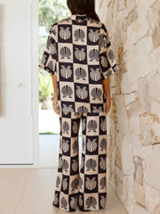 Shell print silk pajama set in black with wide leg pants and short sleeves.