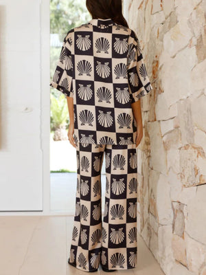 Shell print silk pajama set in black with wide leg pants and short sleeves.