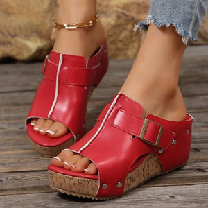 Red open-toe wedge sandals with buckle detail and cork platform.