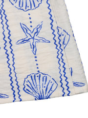 White maternity cover-up romper with blue seashell and starfish print and zigzag trim.