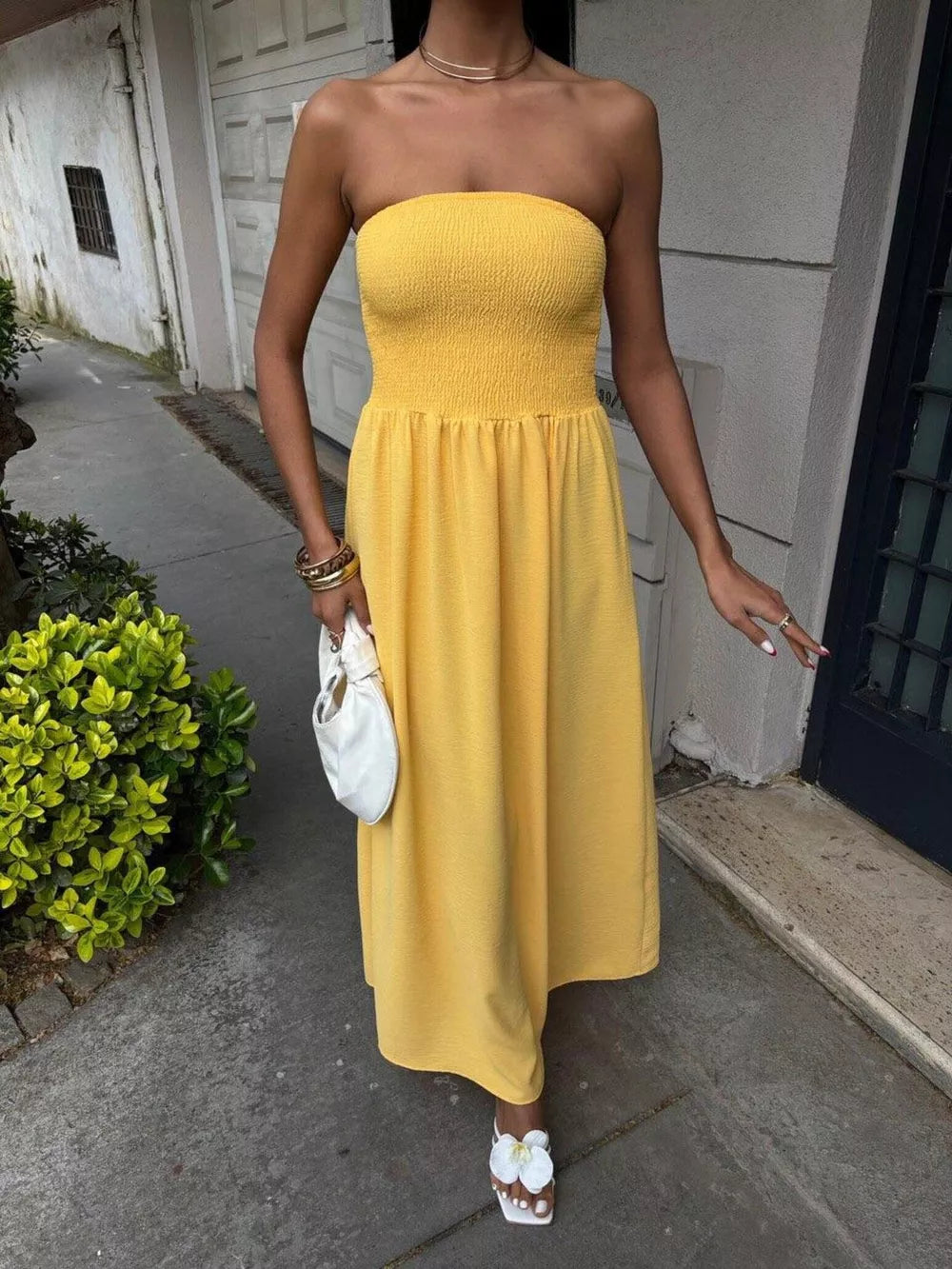 Yellow smocked bodice relaxed maxi dress with a strapless neckline and flowy skirt.