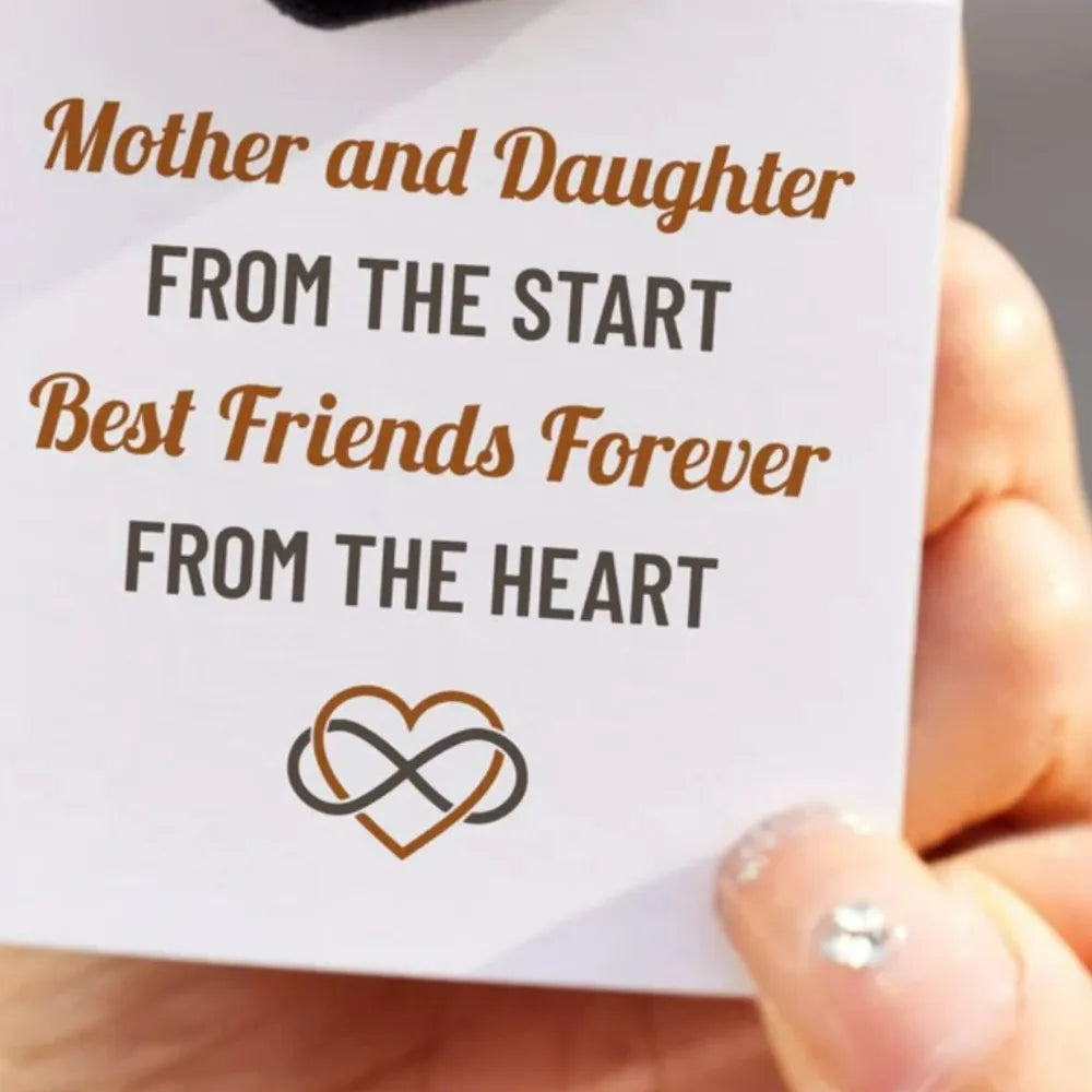 Gold intertwined heart and infinity ring on card with sentimental text.