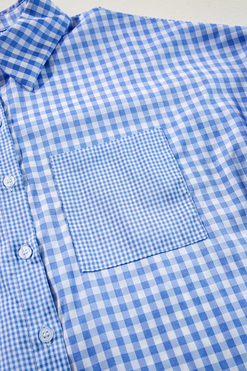 Light blue gingham oversized shirt with patch pocket and buttons.