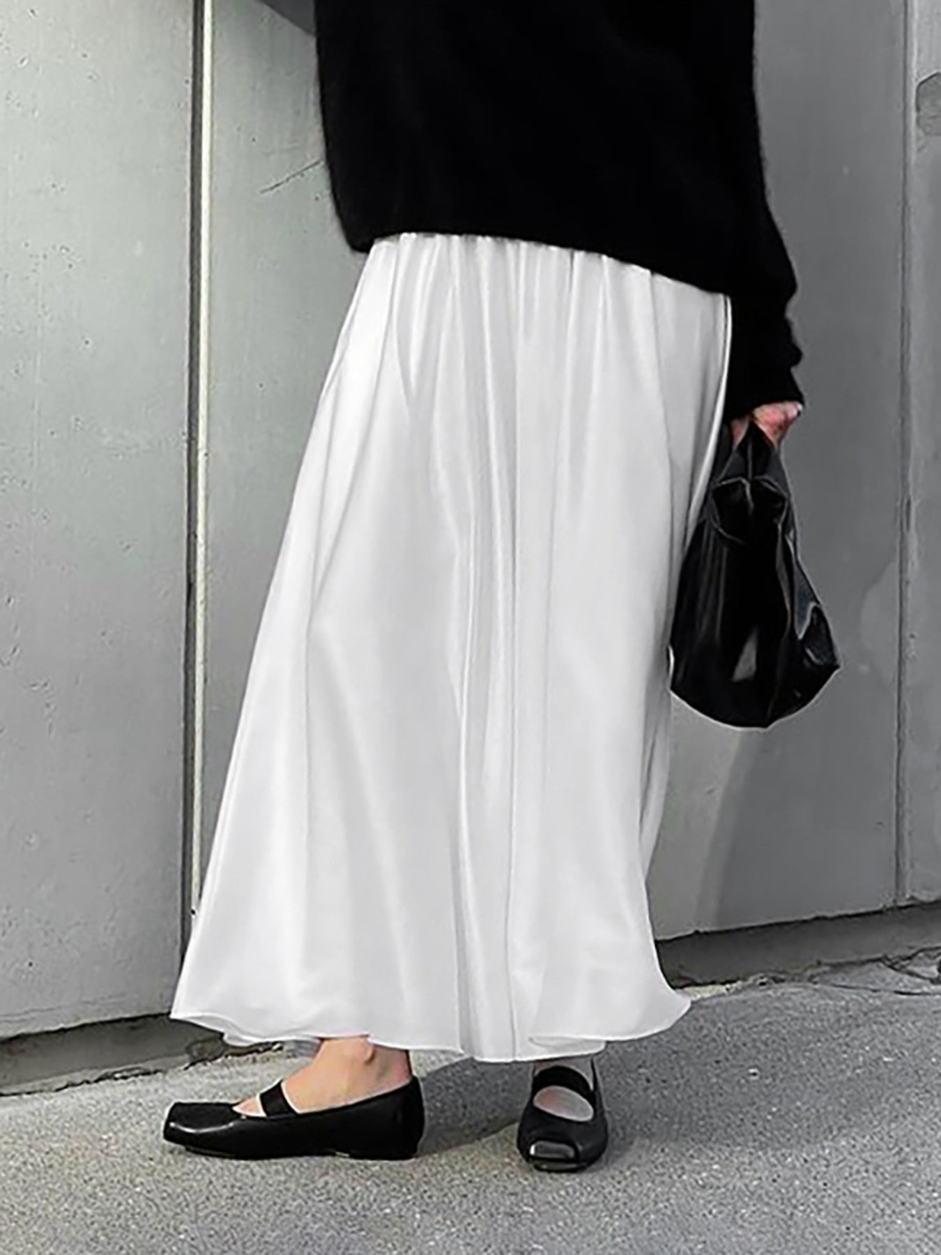 White flowy maxi skirt with pockets and elastic waist, styled with black flats.