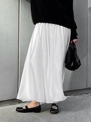 White flowy maxi skirt with pockets and elastic waist, styled with black flats.