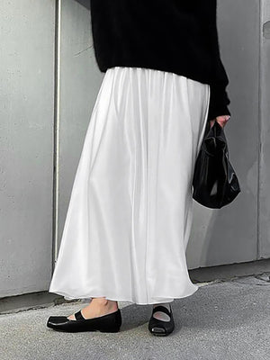 White flowy maxi skirt with pockets and elastic waist, styled with black flats.