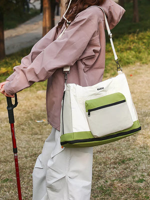 Chic nylon travel bag in green and white with zip pocket and adjustable strap.