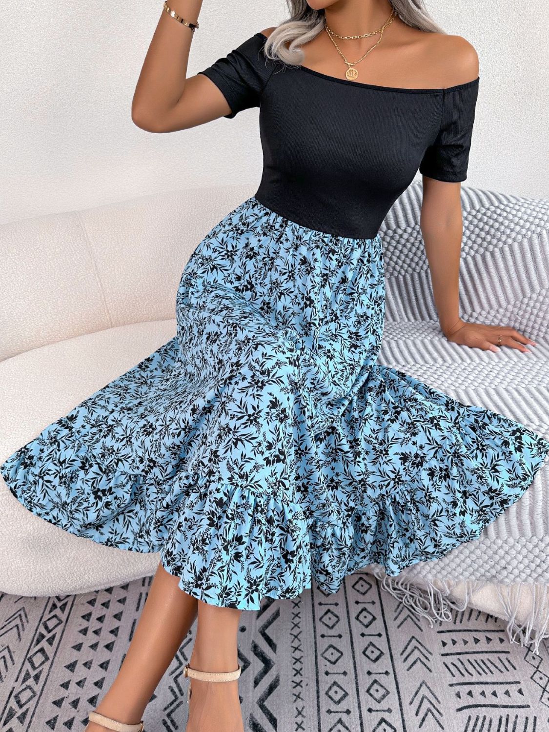 Floral print off-shoulder midi dress in sky blue with black floral pattern and ruffled hem.