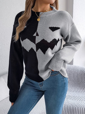 Split-face pumpkin knit sweater in gray and black acrylic with a round neckline and long sleeves.