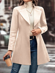 Dust Storm wool blend coat with flared hem and buttoned front, styled with jeans.