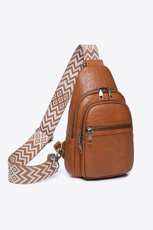Brown leather sling bag with geometric strap and multiple zippered pockets.