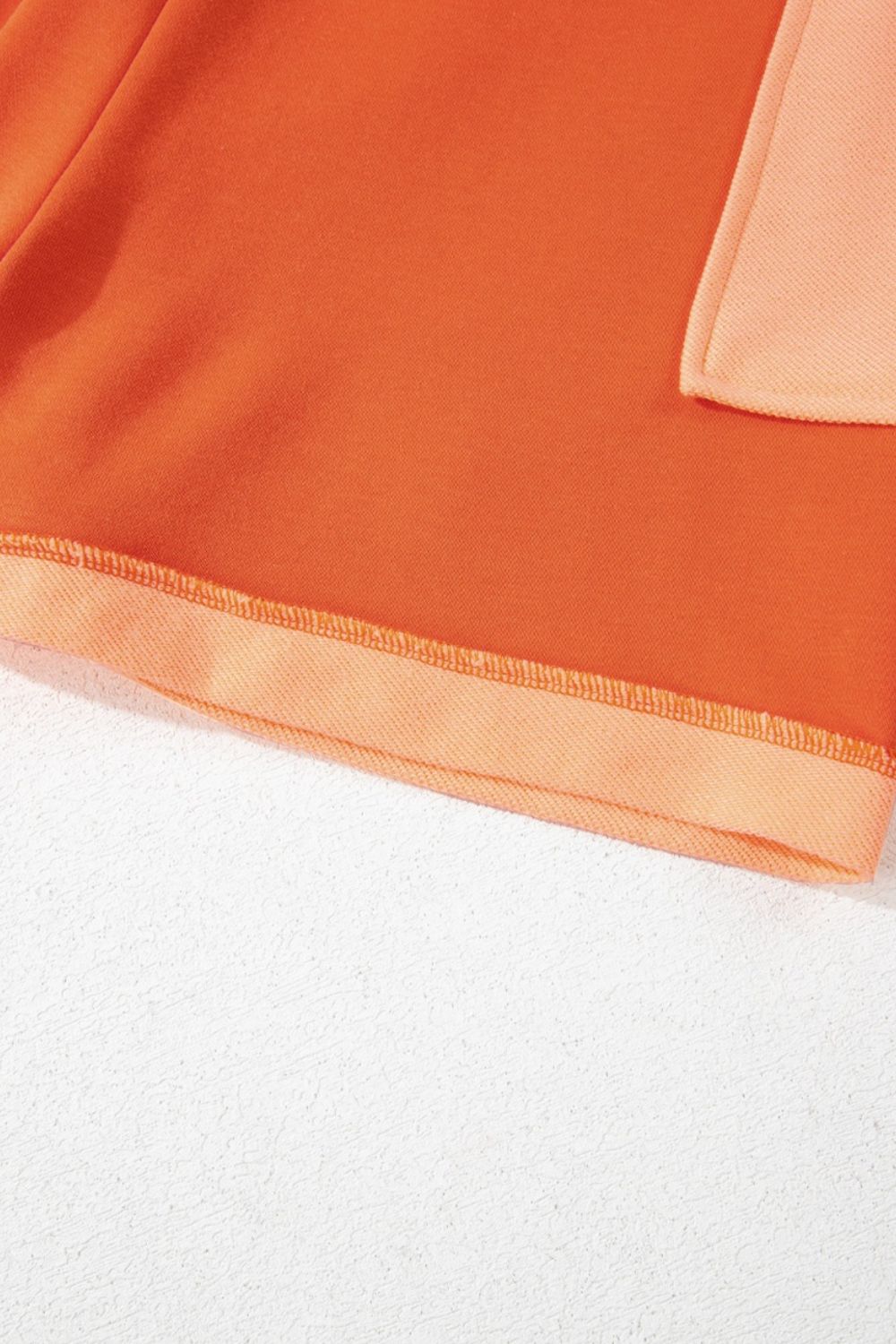 Colorblock V-neck romper in orange with patch pocket detail and contrast hem.